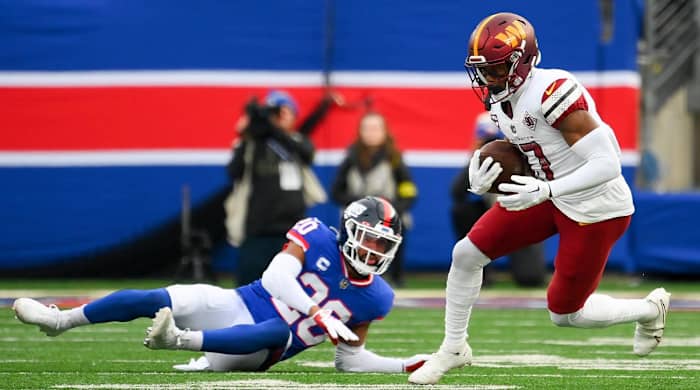 Dec 4, 2022; East Rutherford, New Jersey, USA; Washington Commanders wide receiver Terry McLaurin (17) runs with the ball past New York Giants safety Julian Love (20) during the second half at MetLife Stadium.